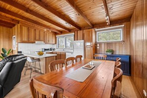 A wooden interior with a dining area, kitchen, and a window with blinds. - The Timeless Coastal - moments walk to town (Aireys Inlet)
