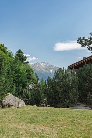 Paesaggio montano con una casa in primo piano.