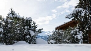 A wooden deck chair in a snowy landscape with a mountain in the background. - Cozy, Alpine • Terrace • Indoor parking (Val de Bagnes)