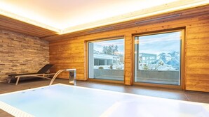 A modern indoor swimming pool with wooden walls and large windows. - Ski-in/Ski-out • Mountain View • Spa & Sauna (Nendaz)