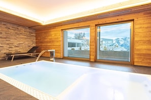 Ein modernes Hallenbad mit Holzwänden und großen Fenstern.