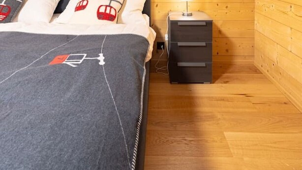 A bedroom with a bed, pillows, a bedside table, and a lamp. - Ski-in/Ski-out • Mountain View • Spa & Sauna (Nendaz)