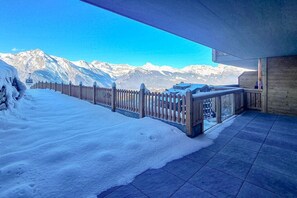 Ein mit Schnee bedeckter Balkon mit Bergblick.