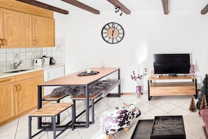 A compact living space with a kitchen, dining area, and a TV. - Cozy & Bright • 1 Bedroom • Ovronnaz (Leytron)