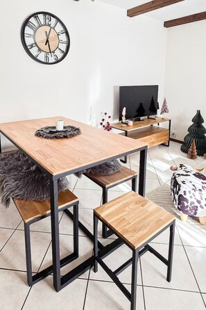 A modern dining area with a wooden table, benches, and a black metal frame. - Cozy & Bright • 1 Bedroom • Ovronnaz (Leytron)