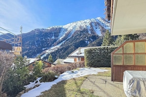 A residential area with a mountain backdrop, a wooden structure with a window, and a snow-covered ground. - Cozy & Bright • 1 Bedroom • Ovronnaz (Leytron)