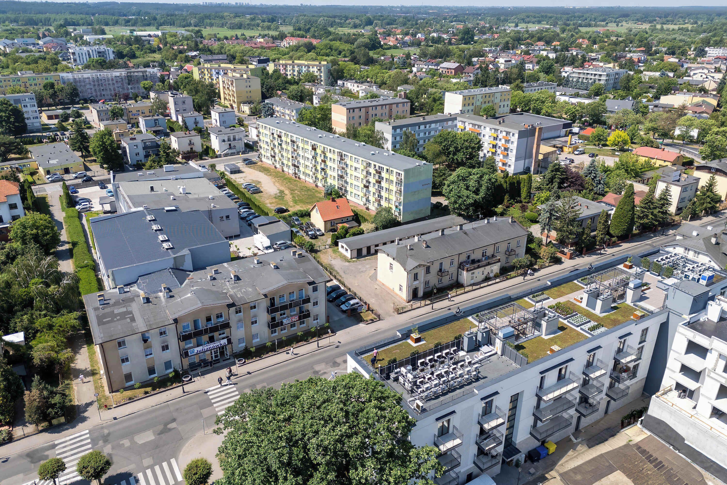 Vista aérea de uma área residencial com vários edifícios de apartamentos, ruas e vegetação.