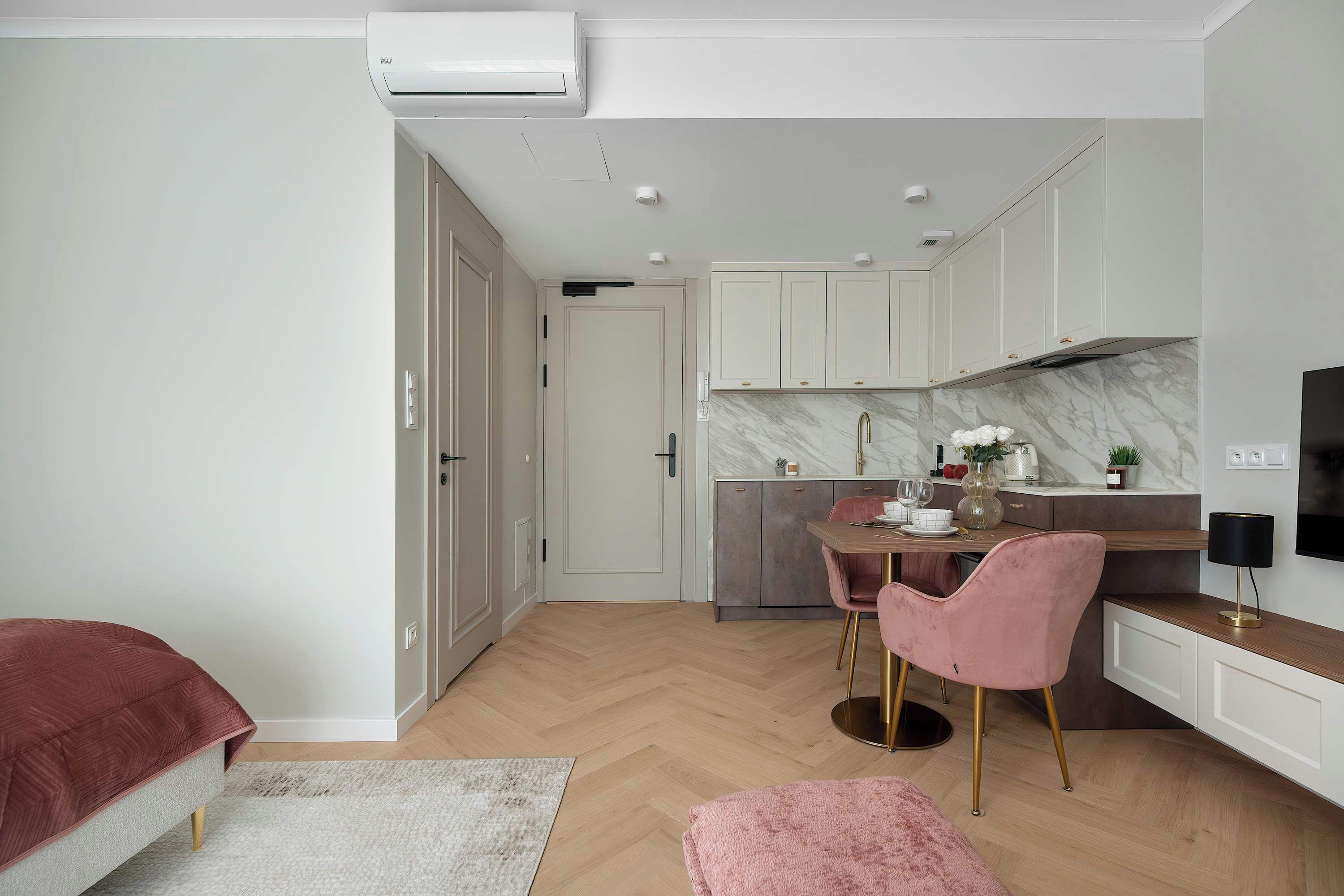 Una cocina compacta con comedor, televisor y una pequeña zona de estar.