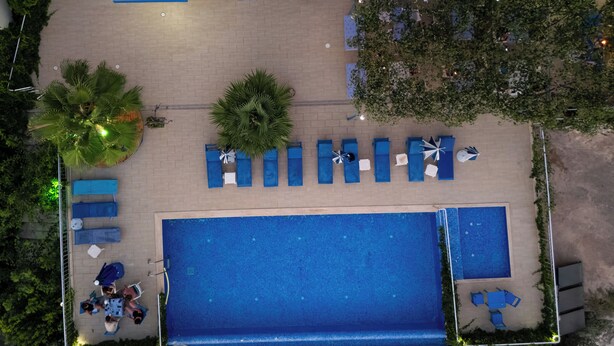 Area piscina sul tetto con sedie a sdraio e una piscina.