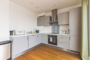 Eine moderne Küche mit Mikrowelle, Wasserkocher und Backofen.