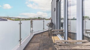 Eine Dachterrasse mit Blick auf den Himmel und entfernte Gebäude.