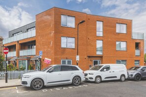 A multi-story building with a brick facade, a no entry sign, and a parking sign indicating a 2-hour limit. - Cozy 1BDR Flat with Fast WiFi near Heathrow (Greater London)