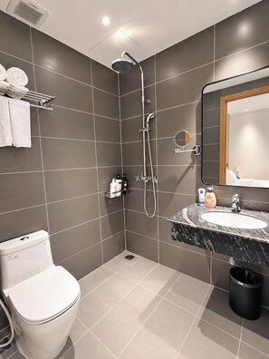 Une salle de bain moderne équipée d’une douche, de toilettes et d’un lavabo.