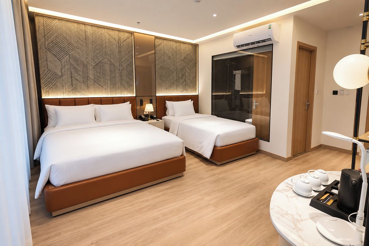A hotel room with two beds, a minibar, a mirror, and a shower area.