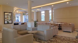 A modern lounge area with sofas, a coffee table, and a bar area with a view.