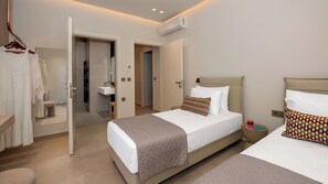 A hotel room with two beds, a bathroom, and a walk-in closet. - VaMa Luxury Living-8BR Design Villa with Heated Pool and Playroom (Episkopi Rethymnou)
