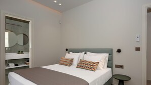Un dormitorio moderno con cama, mesitas de noche, un espejo y una lámpara de pared.
