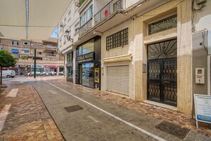 A street with closed shops, a visible ATM, and a sign for a massage and wellness center. - Central Apartment 'Apto Anabel Nerja' (Nerja)