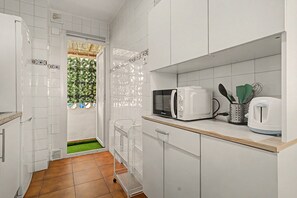 A modern kitchen with white cabinets, a microwave, a kettle, and a small sink. - Central Apartment 'Apto Anabel Nerja' (Nerja)
