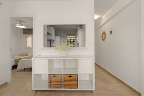 A modern living room with a white console table, a large mirror, and wicker baskets. - Central Apartment 'Apto Anabel Nerja' (Nerja)