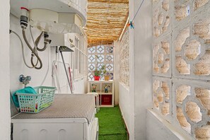 A laundry room with a washing machine, a drying rack, and a small shelf with decorative items. - Central Apartment 'Apto Anabel Nerja' (Nerja)