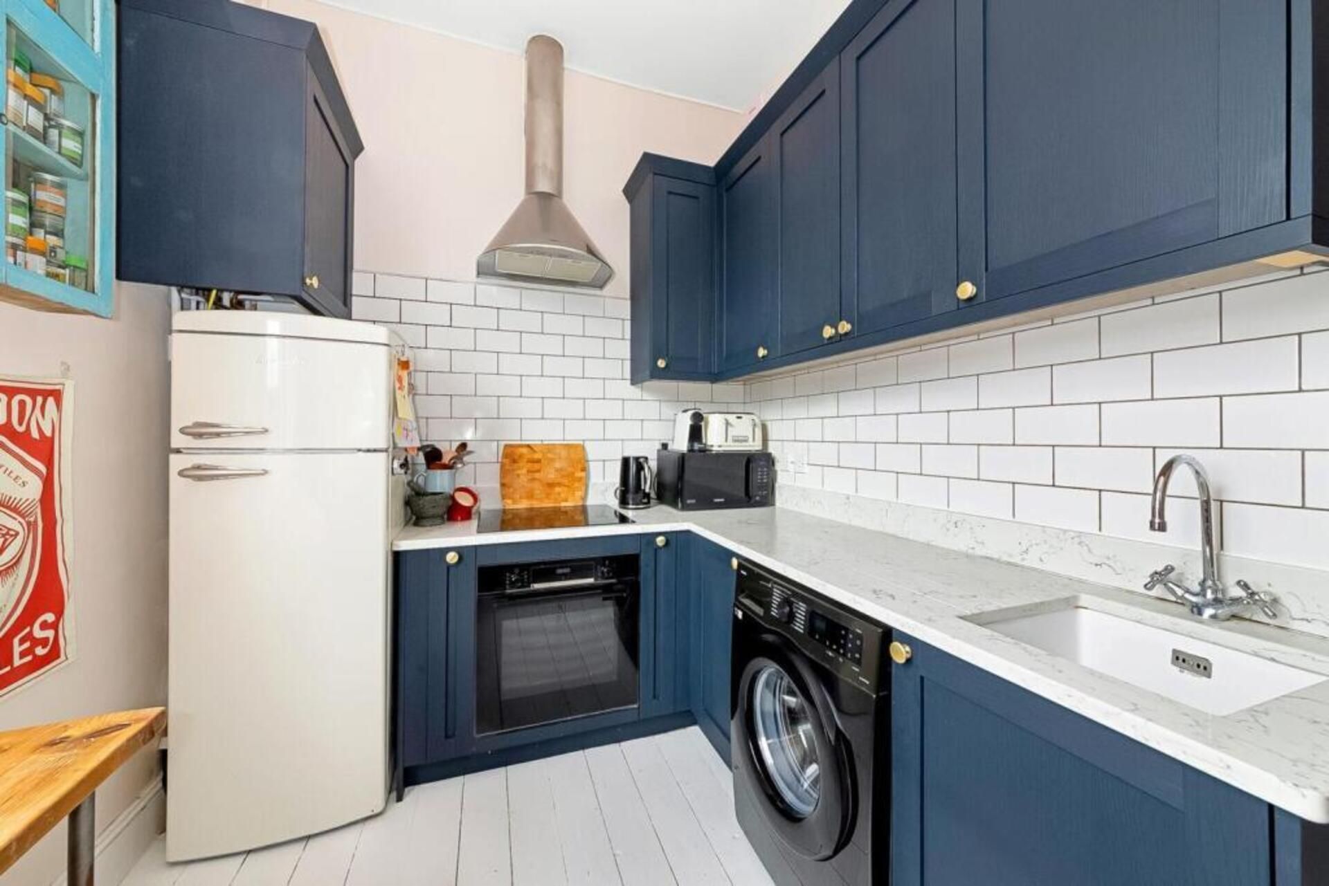 Une cuisine compacte équipée d’un lave-linge, d’un lave-vaisselle et d’un four encastré.