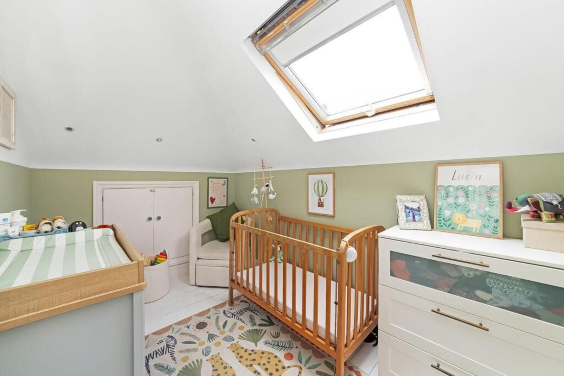 A child's room with a crib, a changing table, and a dresser.