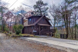 Ein rustikales Blockhaus mit Veranda, Schornstein und Satellitenschüssel.