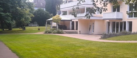 A two-story building with a covered patio area and a well-maintained lawn.