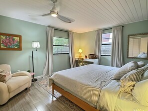 A bedroom with a bed, a chair, a desk, and a ceiling fan. - Garden Oasis Retreat — Your Private Sarasota Escape (Sarasota)