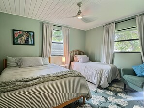A bedroom with two beds, a nightstand, a lamp, and a window with curtains. - Garden Oasis Retreat — Your Private Sarasota Escape (Sarasota)
