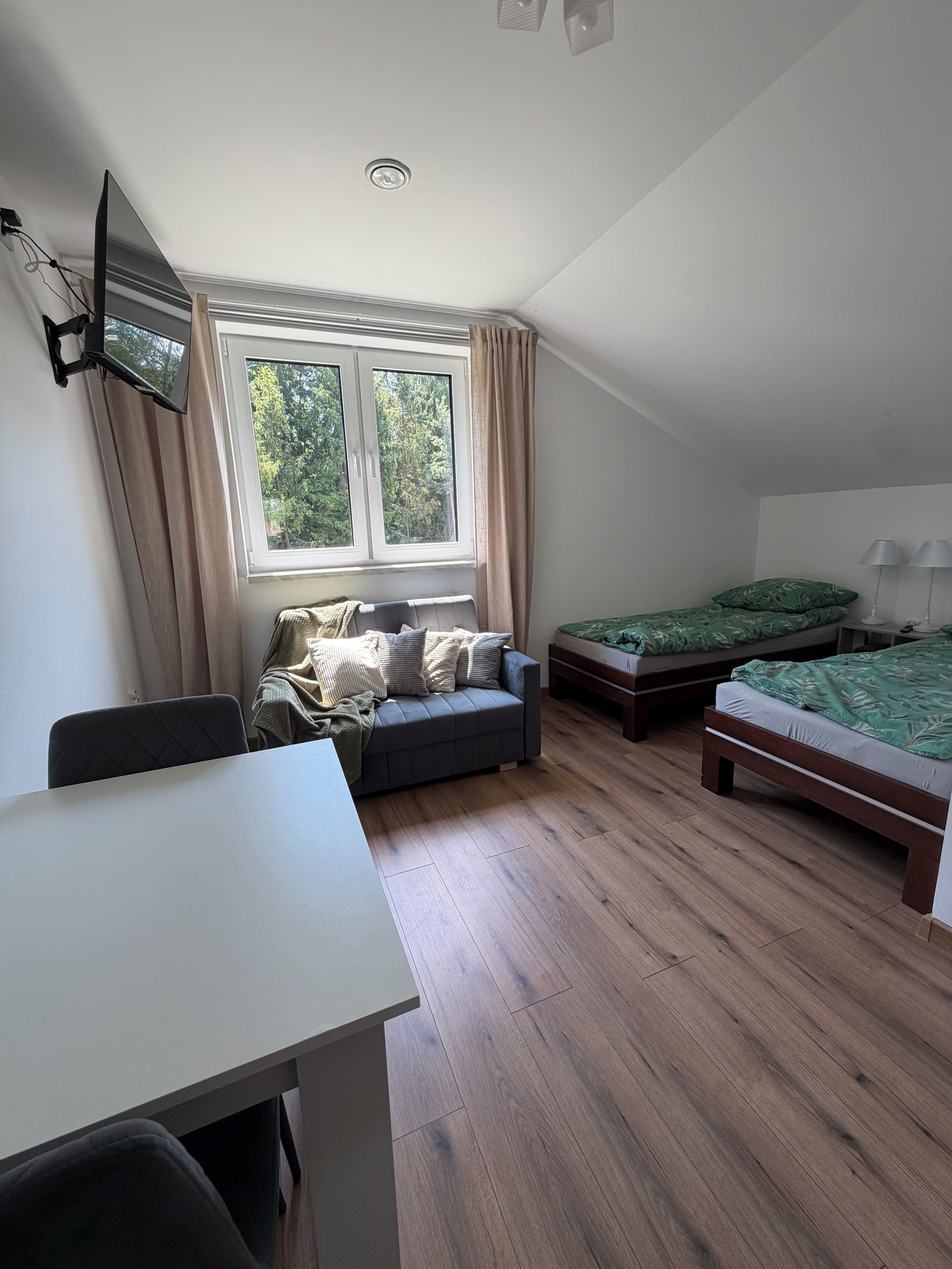 Una habitación con cama, sofá, mesa y ventana.