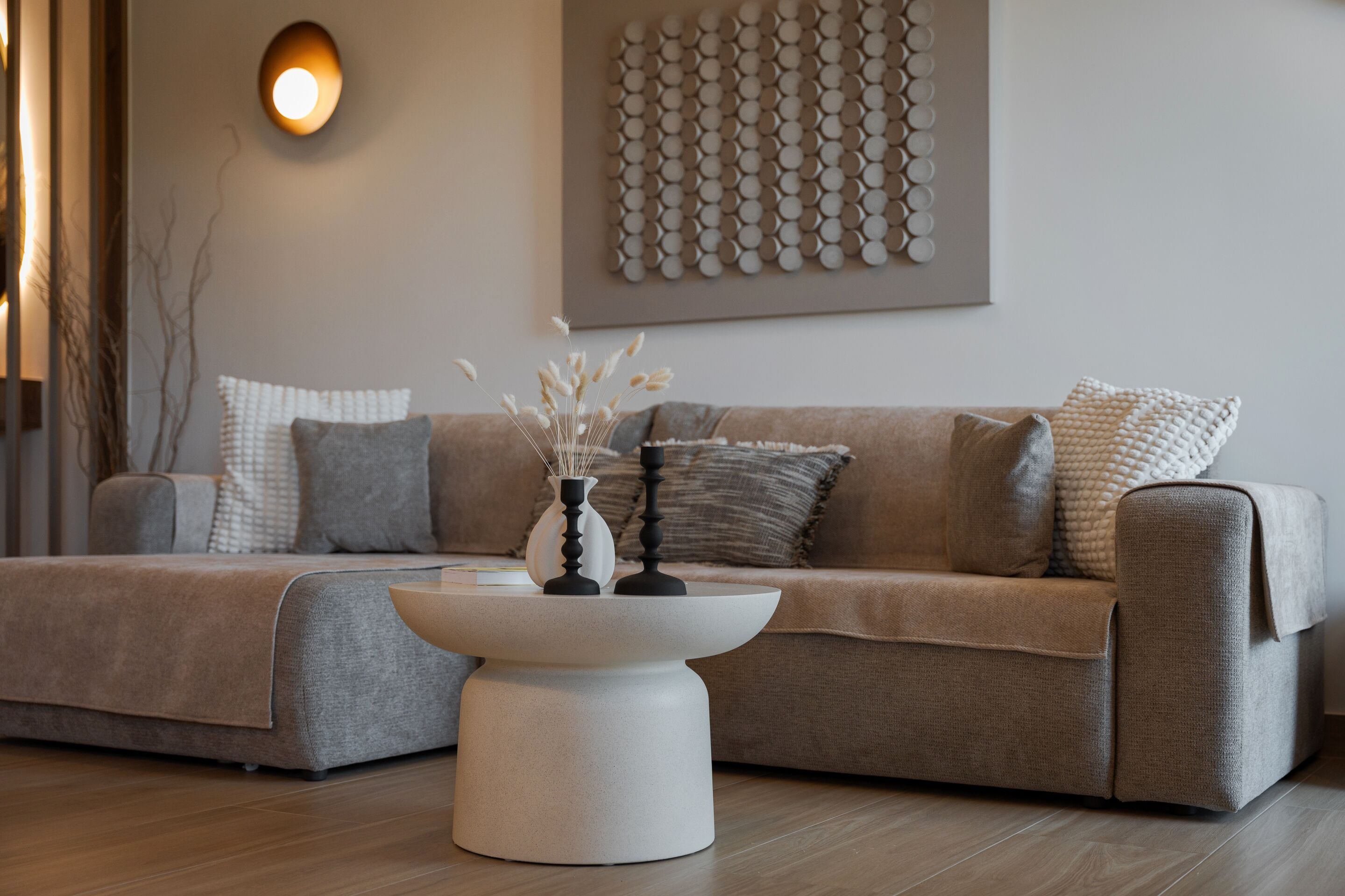A modern living room with a sofa, a coffee table, and decorative pillows.