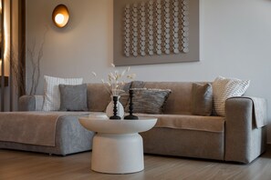 Un salon moderne avec un canapé, une table basse et des coussins décoratifs.