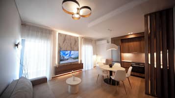 Apartamento, 2 habitaciones | Zona de estar | Smart TV de 65 pulgadas con canales por cable, Netflix