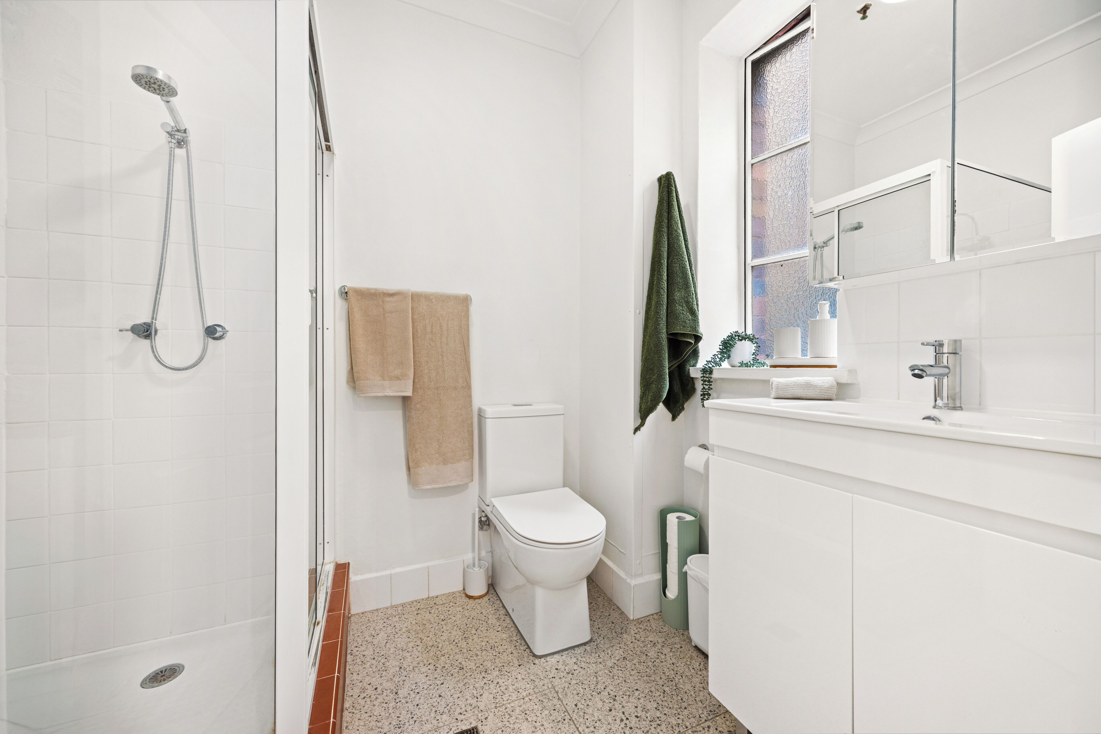 Un baño con ducha, inodoro y lavamanos.