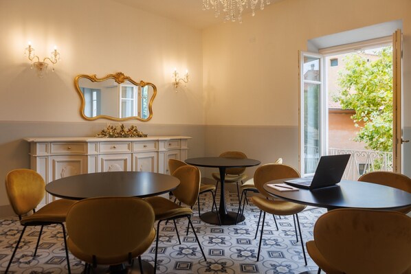 A room with a dining area, a large mirror, and a laptop on a table.