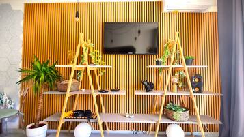 Una sala de estar moderna con un televisor instalado en una pared de madera, un sofá y una mesa de centro.