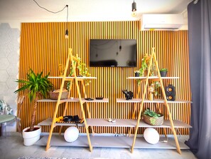 Una sala de estar moderna con un televisor instalado en una pared de madera, un sofá y una mesa de centro.