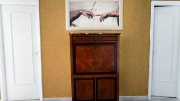 Un mueble de madera con encimera de mármol frente a una pared amarilla, flanqueado por puertas blancas.