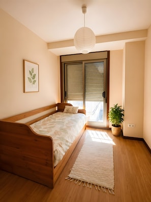 A bedroom with a wooden bed, a large window with blinds, a hanging light fixture, and a framed plant on the wall. - Apartment '2 Bedroom On The Beach' with Sea View and Wi-Fi (Moaña)