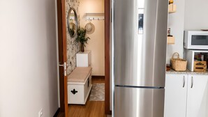 A kitchen with a stainless steel refrigerator, white cabinets, a microwave, and a wooden floor. - Apartment '2 Bedroom  On The Beach' with Sea View and Wi-Fi (Moaña)