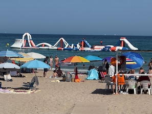 A beach with inflatable structures, umbrellas, and beach chairs. - Beautiful villa with a pool, ideal for 1 or 2 families (Busot)