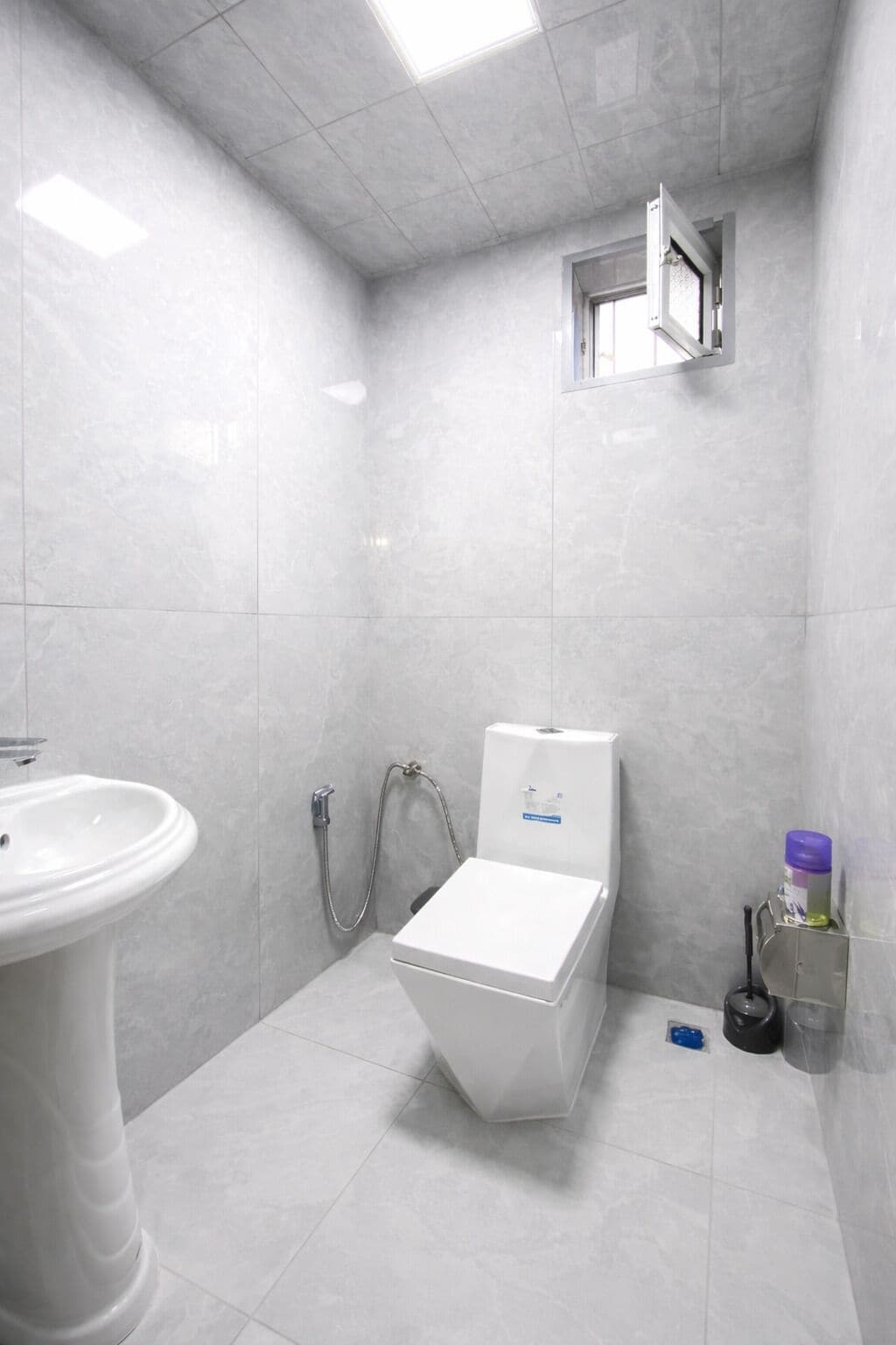 Une petite salle de bain moderne équipée de toilettes, d’un bidet et d’un lavabo.