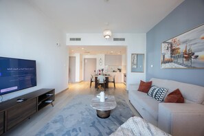 Ein modernes Wohnzimmer mit Flachbildfernseher, einer Couch und einem Couchtisch.