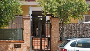 A residential building with a gated entrance, a car parked in front, and a tree providing shade. - Home Joséphine - Caserta - Triple Room with Private Bathroom (Caserta)