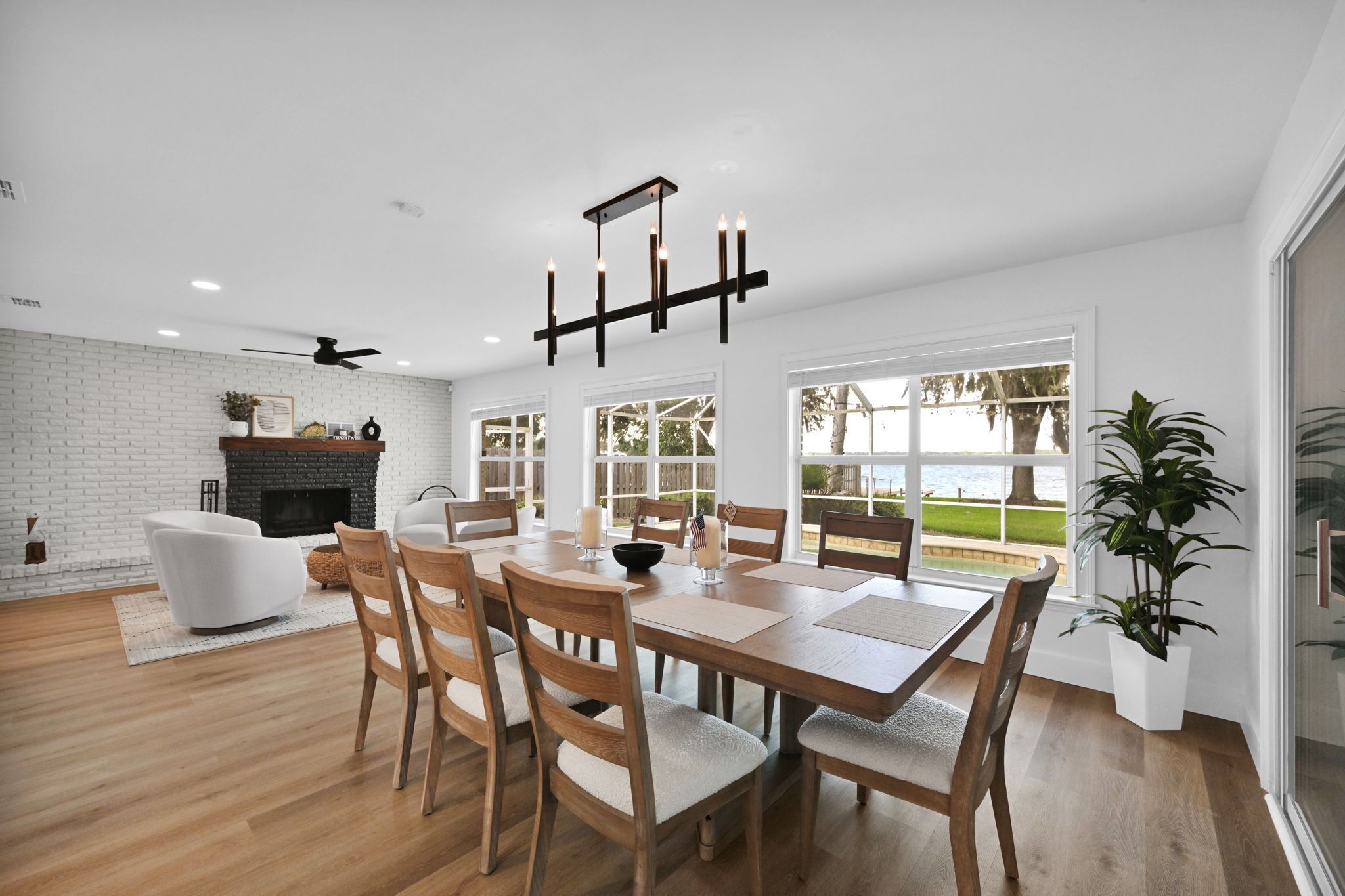 A modern dining area with a brick fireplace, wooden dining table, and chairs.