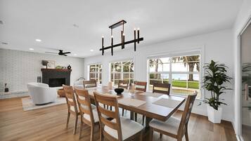 A modern dining area with a brick fireplace, wooden dining table, and chairs.