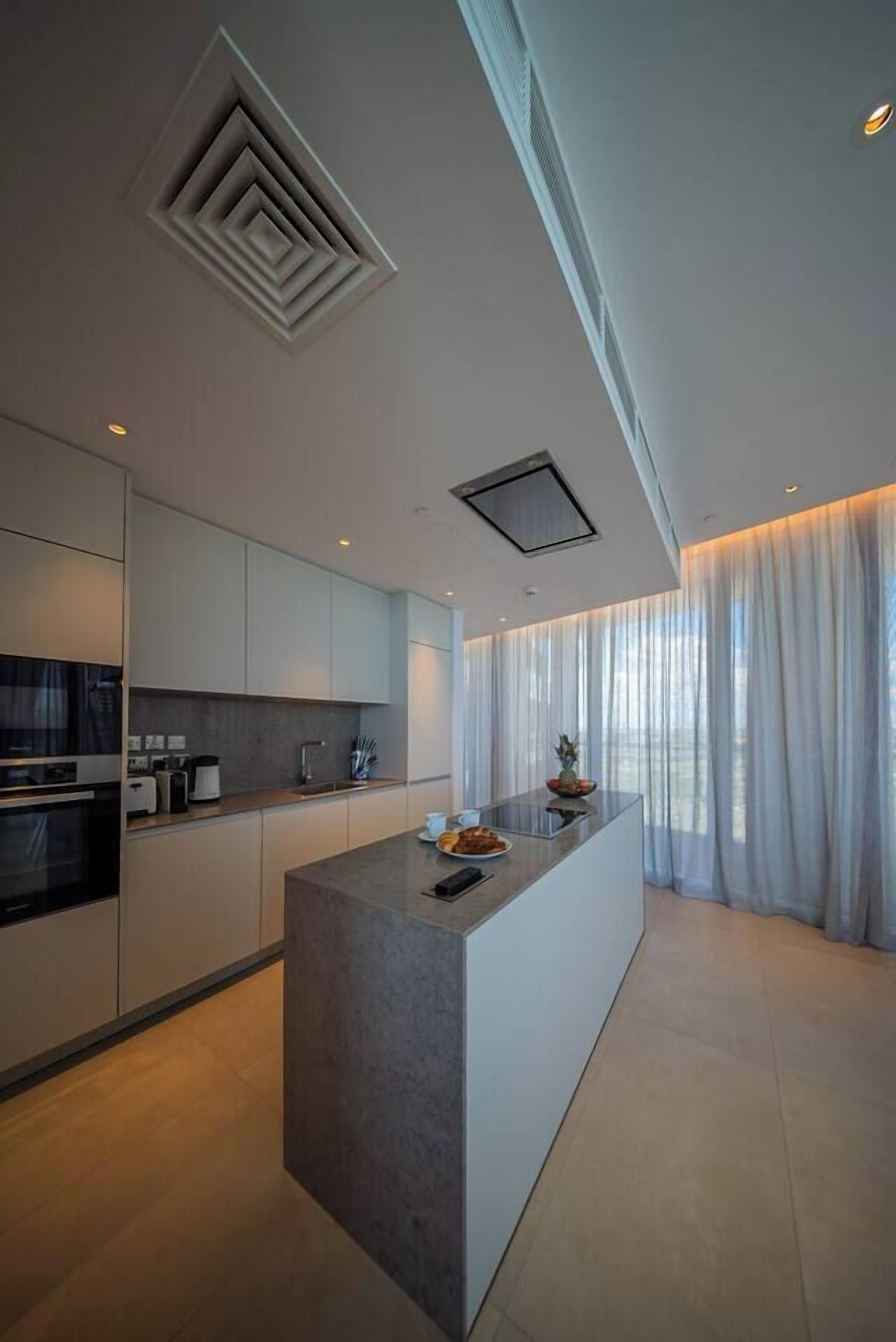 Een moderne keuken met een centraal eiland, ingebouwde apparatuur en een strak design.