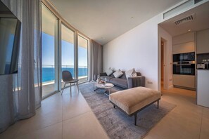 A modern living room with a sofa, a coffee table, and a view of the ocean. - Napa Horizon | Sea Front | Marina Tower 1702 (Ayia Napa)
